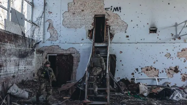 Українські військові у зруйнованій будівлі в Марʼїнці, лютий 2022 року