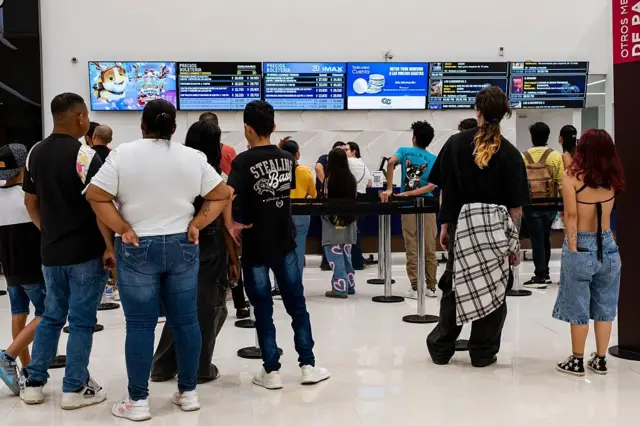 Um grupo de pessoas, visto de costas, faz fila em um centro de lazer de Bogotá, na Colômbia