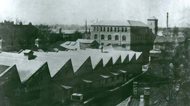 Fotografía antigua de varios edificios antiguos con techos inclinados.