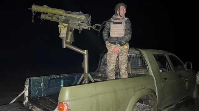 El único colega hombre, Serhiy, con una ametralladora montada en el platón de una camioneta. 