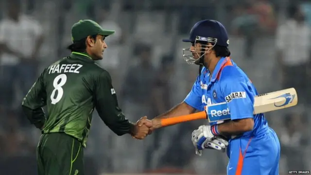 Mahendra Singh Dhoni (R) shakes hands with Pakistan's Mohammad Hafeez