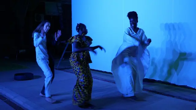 La danseuse franco-suisse Nina Berclaz, Hadiako Sanou (épouse de Maboudou) et Latifatou Ouédraogo dansent lors d'une répétition à la veille de la première du premier acte de Là-bas ou Ici, à l'Institut français de Ouagadougou, le 22 avril 2021.