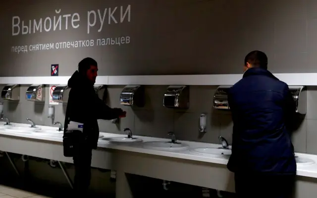 "Самая легкая цель — это мигранты": как в России работает новый реестр «контролируемых лиц» 6 Иностраные граждане моют руки перед дактилоскопической регистрацией на территории Многофункционального миграционного центра