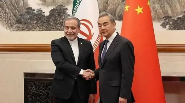 وزیر خارجه ایران در حال فشردن دست وزیر خارجه چین دیده می‌شود. 