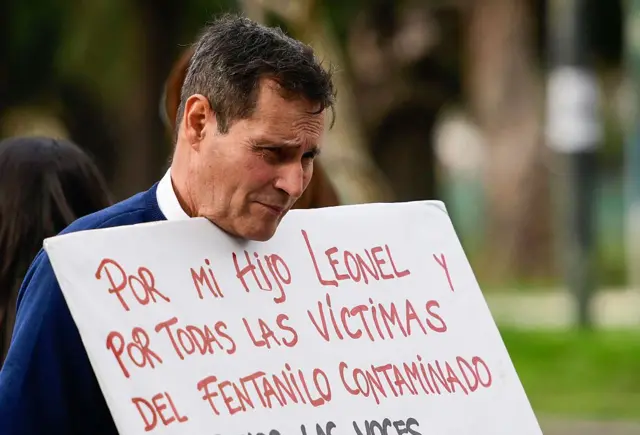 Padre de familia sostiene un letrero sobre las victimas del fentanilo infectado. 