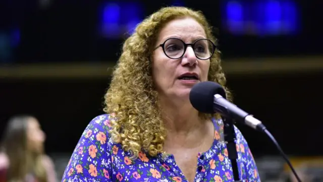 Jandira Feghali falando no microfone na Câmara