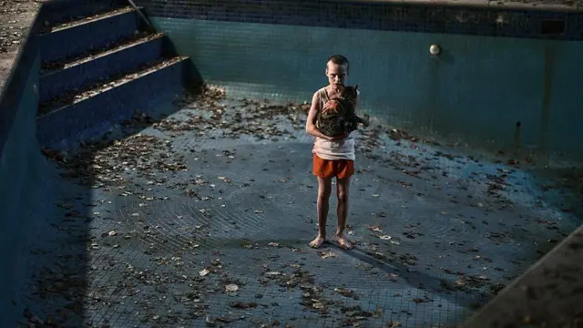Cena de 'Faça Ela Voltar' mostra um menino de pé em uma piscina vazia