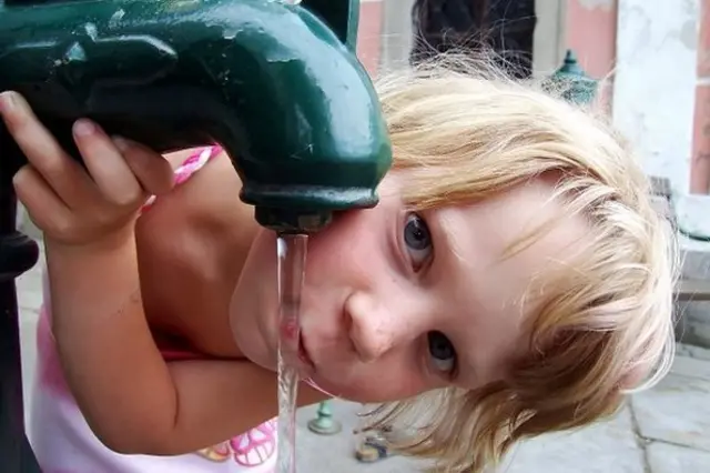 Дівчинка п'є воду