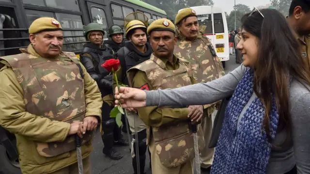 પોલીસને ફૂલ આપતી યુવતી