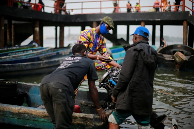 Un homme répare le moteur d'un bateau à la jetée d'Ibaka sur l'île d'Okrika, dans l'État de Rivers, au Nigeria - vendredi 28 janvier 2022.