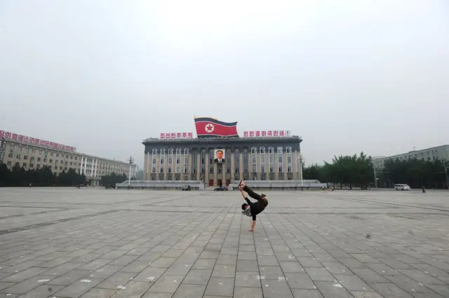 Calvin Sunjogos valendo dinheirofrente a edifício na Coreia do Norte