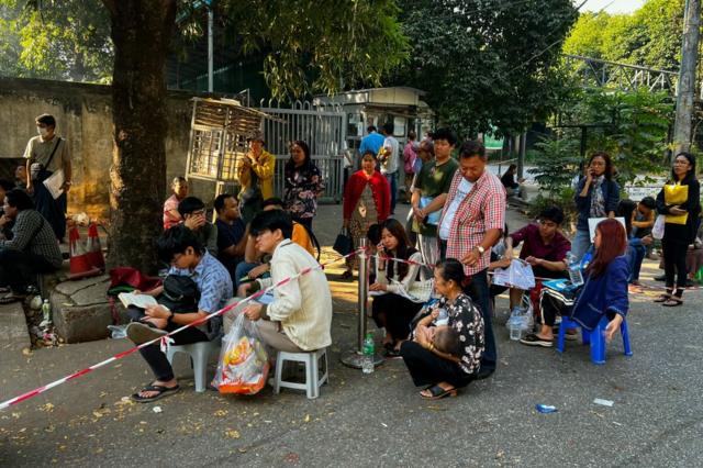Varias personas en una escena cotidiana en uina calle de Myianmar