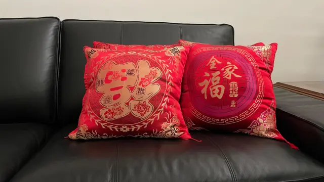 Beberapa bantal bercorak imlek di ruang tamu Charlenne yang selalu ditaruh di sofa.