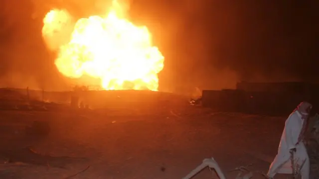 رجل يمشي بجانب انفجار تسبب فيه هجوم استهدف أنبوب الغاز في العريش شمال سيناء