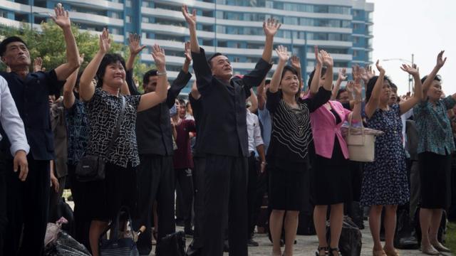 平壤民眾在街頭大電視屏幕前收看核試驗成功消息後集體舉手歡呼（3/9/2017）