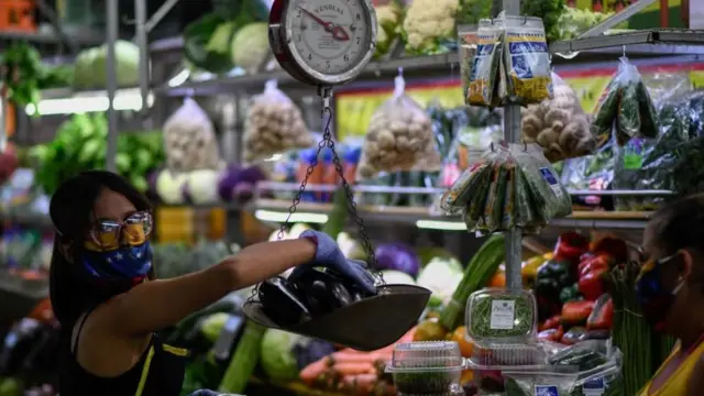 Una mujer pesando vegetales (foto genérica)