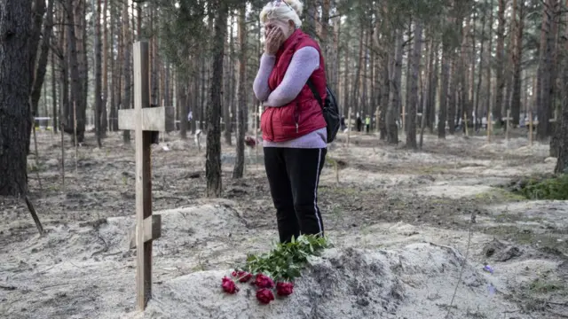 রুশ বাহিনীর হাত থেকে মুক্ত ইজিযুমের এক কবরখানায় নিহত স্বামীর জন্য কাঁদছেন এক ইউক্রেনীয়ান নারী।