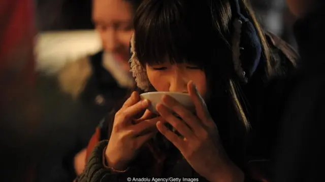 Seorang perempuan meminum amazake