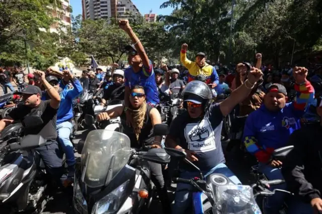 Motoqueiros erguendo as mãos