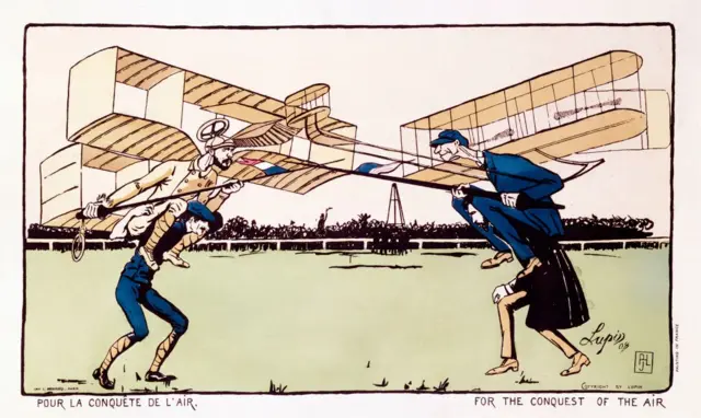 Litografía coloreada de «Lupin», impresa por L. Monrocq, París, que muestra a Wilbur Wright (1867-1912) y Alberto Santos-Dumont (1873-1932), ambos con alas de avión y luchando a hombros de otros dos hombres. Wright y Santos-Dumont estuvieron a la vanguardia de la aviación en los inicios del vuelo a motor.