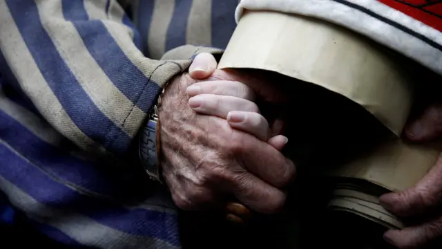 Holocaust survivor Edward Mosberg holds the hand of his granddaughter Jordana Karger