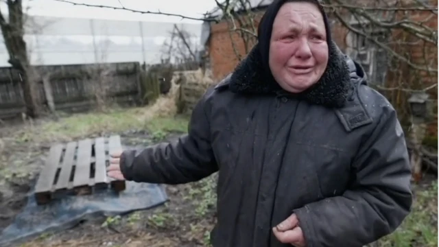 إرينا كوستينكوفا أمام قبر ابنها في الفناء الخلفي لمنزلها.