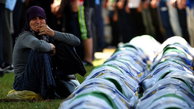 A Bosnian Muslim woman mourns by the caskets of 33 newly identified bodies of the 1995 Srebrenica massacre, on 11 July 2019