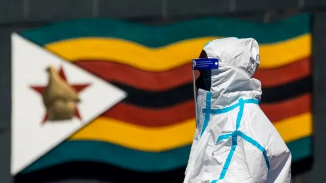 A health worker wearing a protective suit takes a swab from a resident during a door-to-door testing in Zimbabwe.