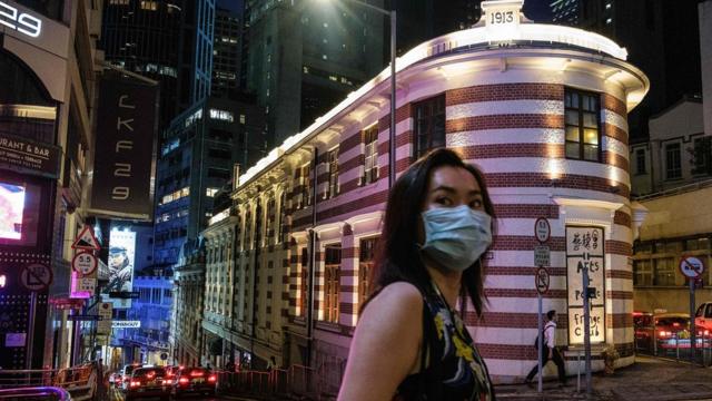 A woman walks past the Fringe Club (back C) building, which is housed in a Grade-I heritage building, the old Dairy farm cold storage depot, built circa 1892 and expanded in 1913, in Hong Kong on May 29, 2020.