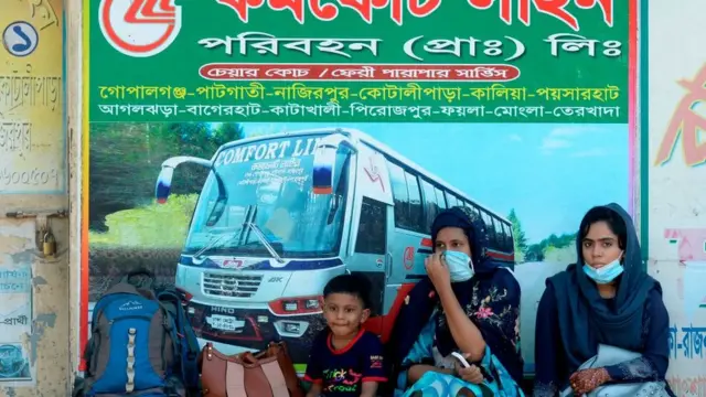 বাড়ি যাবার লক্ষ্যে ঢাকায় বাসের জন্য অপেক্ষা করছে এক পরিবার, ৩১-০৭-২০২০।