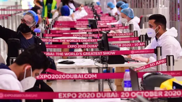 Un touriste prend un selfie avant de subir un examen médical à son arrivée au terminal