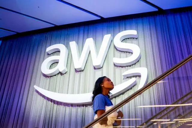 Mujer sube escalera. Detrás hay un logo de AWS