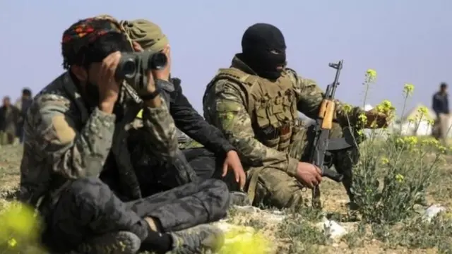 ਅਮਰੀਕੀ ਹਮਾਇਤ ਵਾਲੀਆਂ ਸਾਂਝੀਆਂ ਫੌਜਾਂ ਦੇ ਲੜਾਕੇ ਸੀਰੀਆ ਵਿੱਚ ਆਖ਼ਰੀ ਹੱਲੇ ਤੋਂ ਪਹਿਲਾਂ ਆਮ ਲੋਕਾਂ ਦੇ ਇਲਕਾ ਛੱਡ ਜਾਣ ਦਾ ਇੰਤਜ਼ਾਰ ਕਰਦੇ ਹੋਏ।