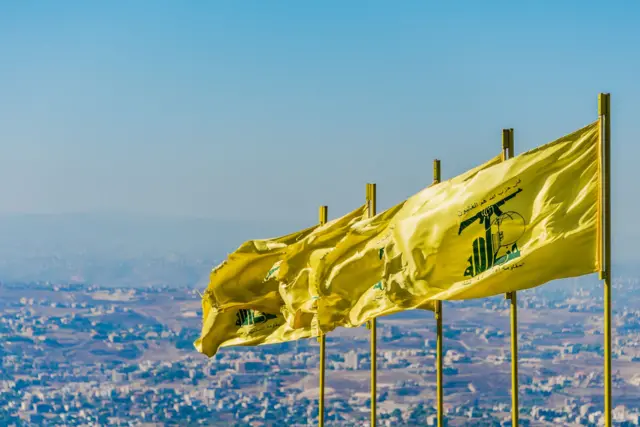 Bandeiras amarelas do Hezbollah, com cidade ao fundo