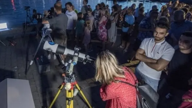 સ્વિત્ઝર્લૅન્ડમાં લૂસર્ન નદી પાસે પૂર્ણ ચંદ્રગ્રહણ જોવા રાહ જોઈ રહેલા લોકો