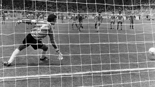 صورة بالأبيض والأسود - حارس مرمى يتلقى هدفاً - هدف بلجيكا ضد العراق في كأس العالم 1986 من ضربة جزاء