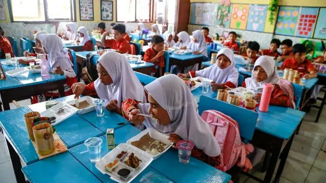 Sejumlah siswa menyantap makanan saat uji coba program makanan bergizi gratis di SD Negeri 3 Kota Ternate, Maluku Utara, Kamis (19/12/2024).