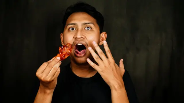 Seorang pria sedang kepedasan makan.