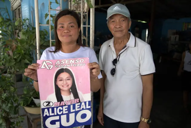 Miah (kiri) dan Francisco (kanan) dengan salah satu poster kampanye wali kota Alice Guo