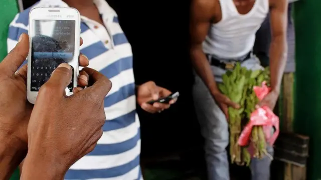 شخص يستخدم هاتفه المحمول في أحد الأسواق