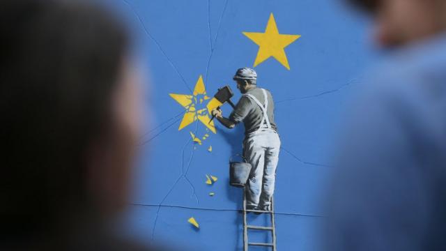 ภาพวาดสี คนกำลังทำลายดาวในธงสหภาพยุโรป
