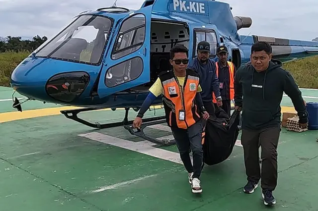 Petugas membawa kantong berisi jenazah pendaki Puncak Carstensz Pyramid yang berhasil dievakuasi di Helipad Bandara UPBU Mozes Kilangin Timika, Kabupaten Mimika, Provinsi Papua Tengah, Minggu (02/03).