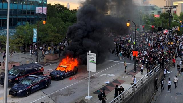 抗议者聚集在佐治亚州亚特兰大的CNN办公室附近时。一辆警车被纵火燃烧。