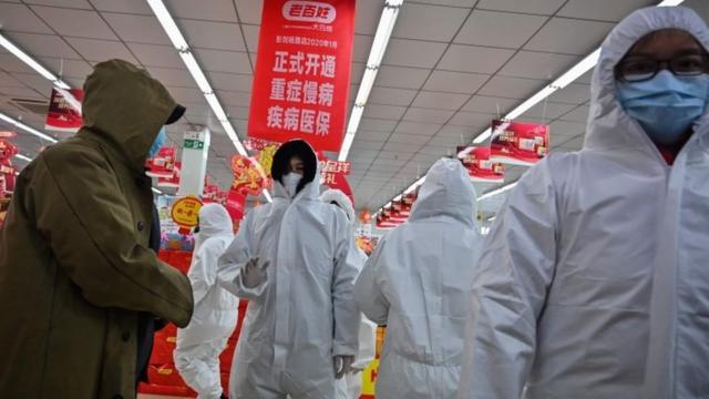우한의 약국 점원들은 방호복과 마스크를 쓰고 손님을 맞이했다