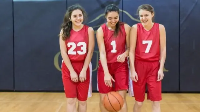 ਬਾਸਿਕਟਬਾਲ ਵਾਲੀ ਲਾਲ ਵਰਦੀ ਵਿੱਚ ਕੁੜੀਆਂ