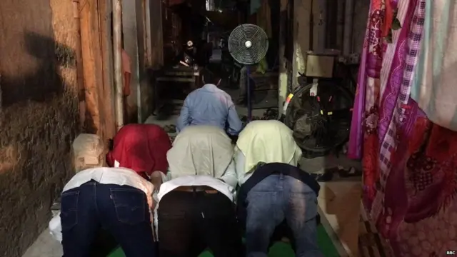 इफ़्तार पार्टी के दौरान नमाज़ अदा करते लोग