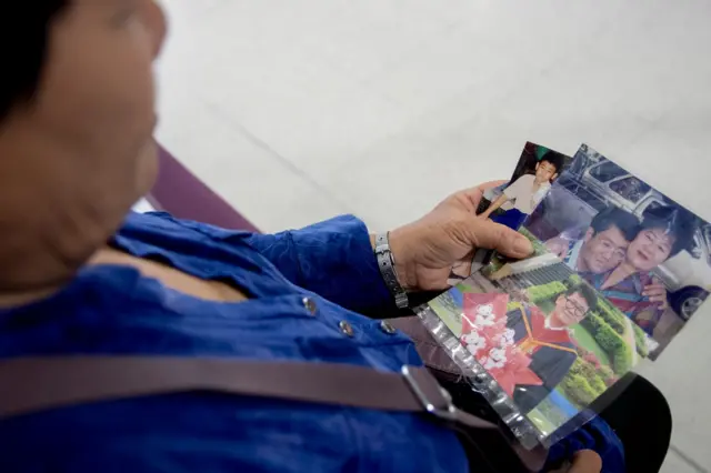 แม่ของสยาม ธีรวุฒิ นั่งดูภาพถ่าย