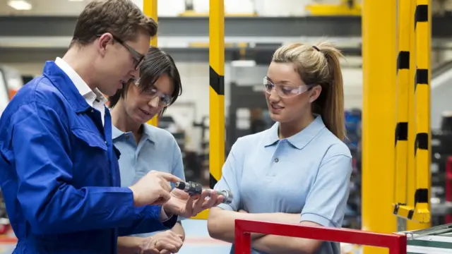 Un hombre y dos mujeres trabajando.