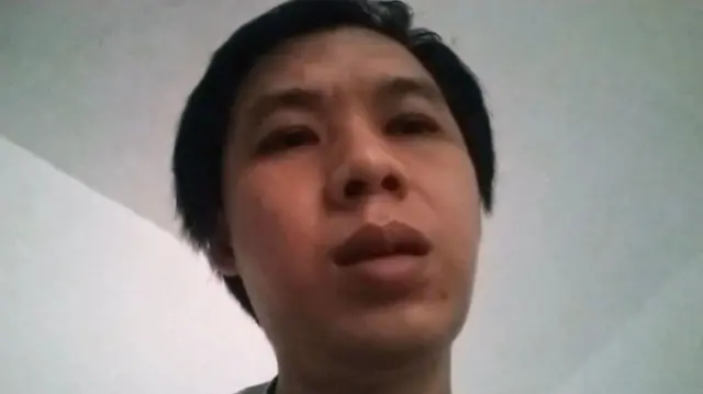 A grainy close-up photo of a man's face, his expression neutral