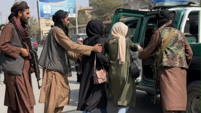 تصویر دو زن که توسط نیروهای طالبان دستگیر شده اند. این زنان به داخل یک موتر پولیس هدایت میشوند.